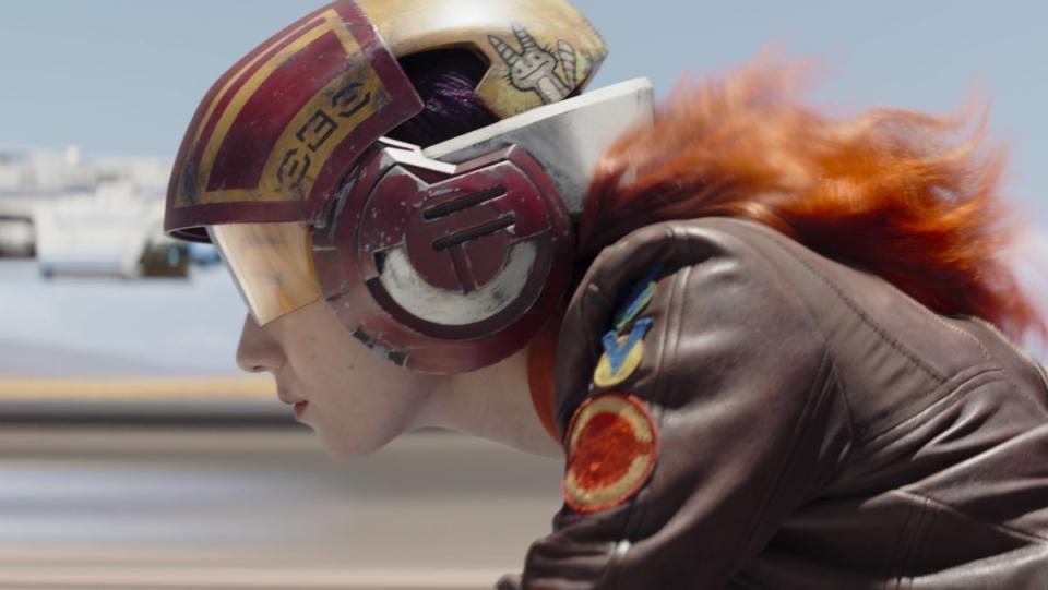Sabine riding a speeder in a brown leather jacket and helmet