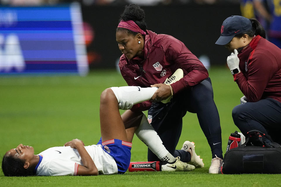 United States' Naomi Girma (4) is helped on the field after injury during the first half against Japan in the SheBelieves Cup women’s soccer tournament, Saturday, April 6, 2024, in Atlanta. (AP Photo/Mike Stewart)