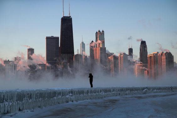 A man walks along an ice-covered break-wall along Lake Michigan while temperatures were hovering around -20F (-29C) on 31 January, 2019 in Chicago, Illinois. (Photo by Scott Olson/Getty Images)