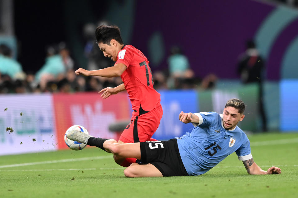 AL RAYYAN, QATAR - NOVEMBER 24: Kangin Lee of Korea Republic is tackled by Federico Valverde of Uruguay during the FIFA World Cup Qatar 2022 Group H match between Uruguay and Korea Republic at Education City Stadium on November 24, 2022 in Al Rayyan, Qatar. (Photo by Stu Forster/Getty Images)