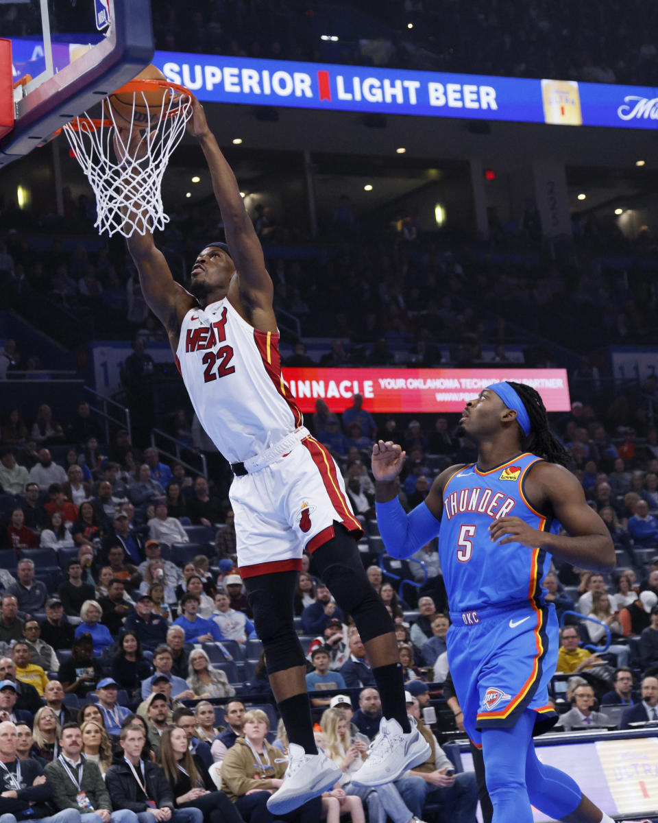 Miami Heat forward Jimmy Butler (22) dunks in front of Oklahoma City Thunder guard Luguentz Dort (5) during the first half of an NBA basketball game Friday, March 8, 2024, in Oklahoma City. (AP Photo/Nate Billings)