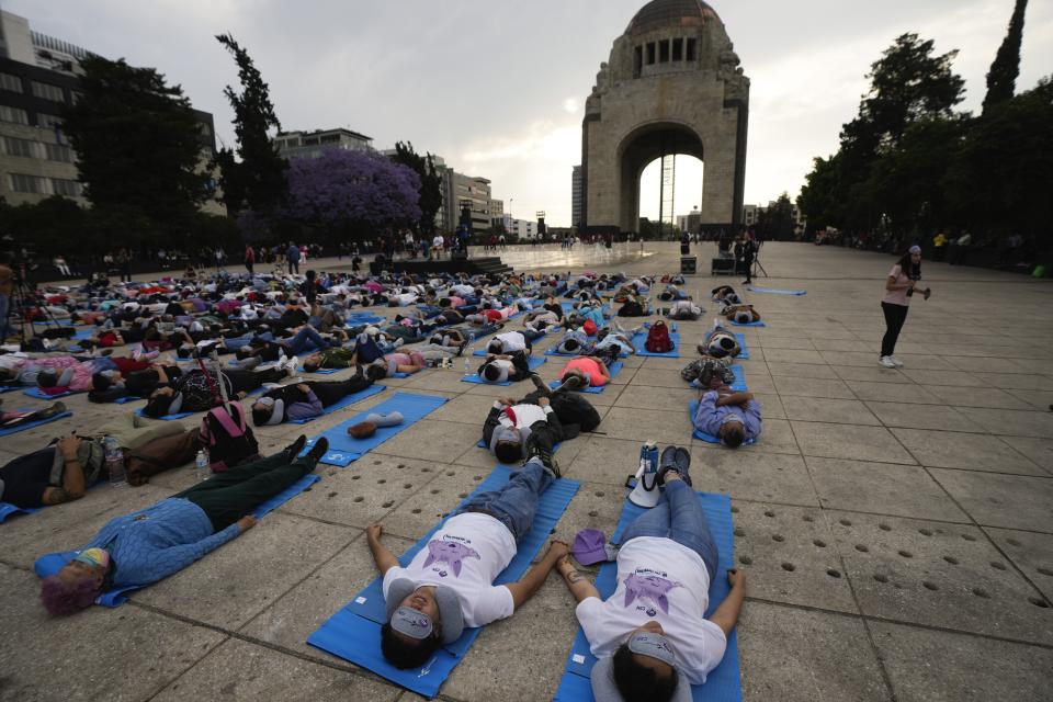 Lolling with bright blue mats, sleeping masks and travel pillows, people lie sprawled out at the base of the iconic Monument to the Revolution to take a nap, in Mexico City, Friday, March 15, 2024. Dubbed the “mass siesta,” the event was in commemoration of World Sleep Day. (AP Photo/Fernando Llano)