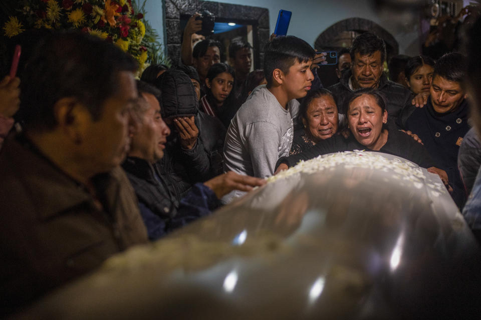 Familiares y amigos reaccionan cuando los cuerpos de Jair Valencia, Misael Olivares y Yovani Valencia llegan a la casa de su familia en San Marcos Atexquilapan, estado de Veracruz, México, el miércoles 13 de julio de 2022. (AP Foto/Félix Márquez)