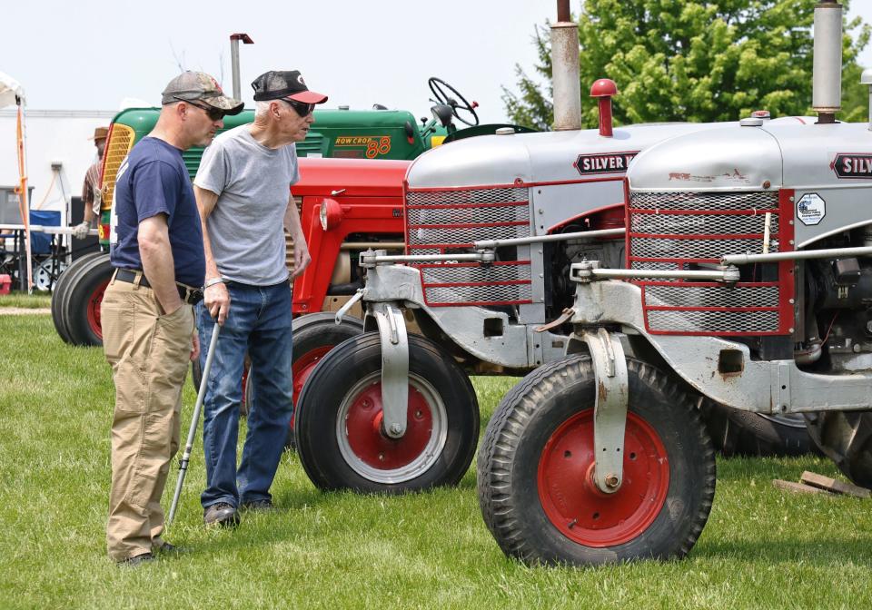 Ron Peterson, right, and son Jeff of Manitou Beach check out the tractors on display May 21, 2023, at the Farmer’s Antique Tractor & Engine Association's spring show.