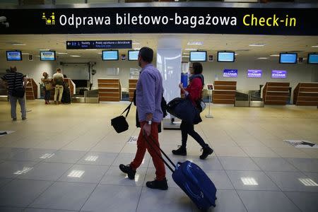 People walk to the check-in desk area at the airport in Lodz October 10, 2014. REUTERS/Kacper Pempel