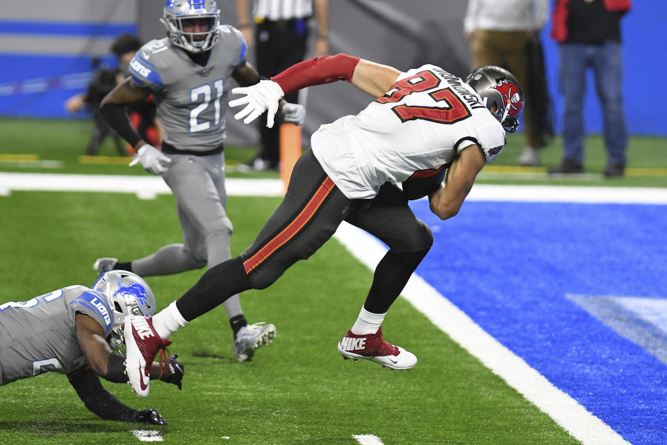 Tampa Bay Buccaneers tight end Rob Gronkowski (87) pulls away from Detroit Lions strong safety Duron Harmon to score during the second half of an NFL football game, Saturday, Dec. 26, 2020, in Detroit. (AP Photo/Lon Horwedel)