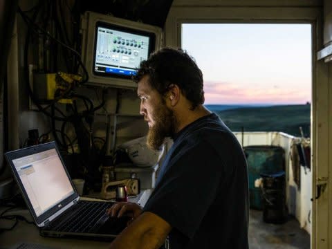 A directional driller reviews computer monitors while drilling for oil in the Bakken shale formation.