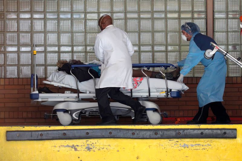 Healthcare workers rush patient on stretcher into Wyckoff Heights Medical Center during outbreak of coronavirus disease (COVID-19) in New York