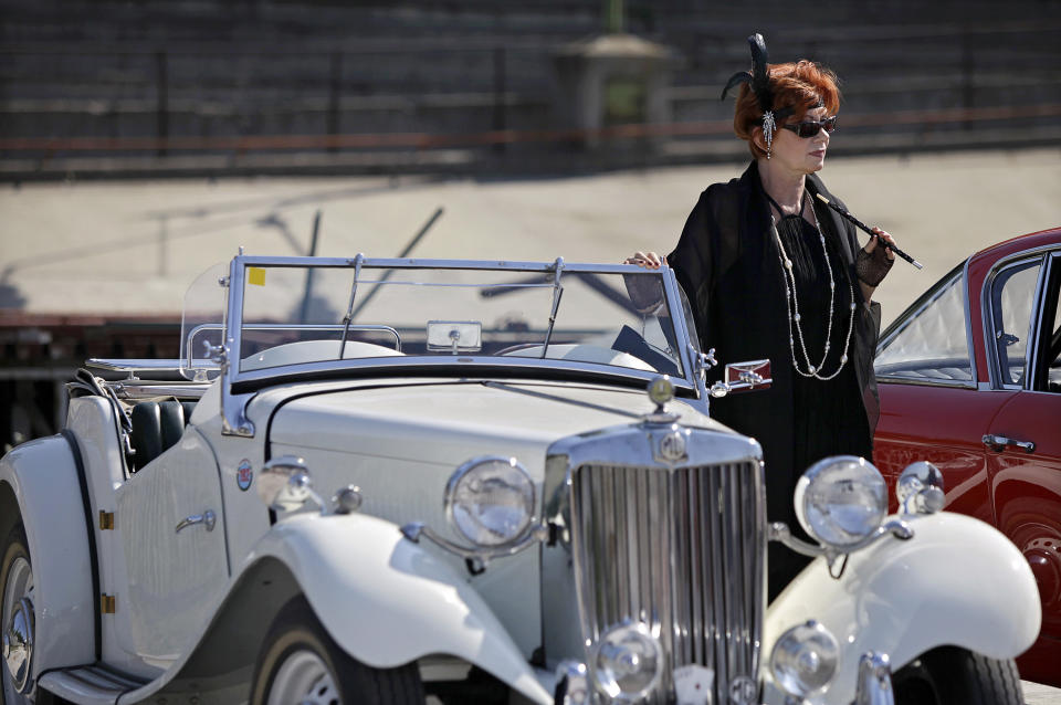 A woman driver waits besides her car near the oval track of a velodrome during an old timer car and motorcycle show in Budapest on May 1, 2012. The event brought life again into the 412 meter long Millennial Velodrome of Budapest, which was built in 1896 and is one of the oldest arenas for track cycling in Europe.  AFP PHOTO / PETER KOHALMIPETER KOHALMI/AFP/GettyImages