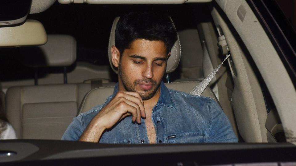 Sidharth Malhotra is engrossed on his phone. 