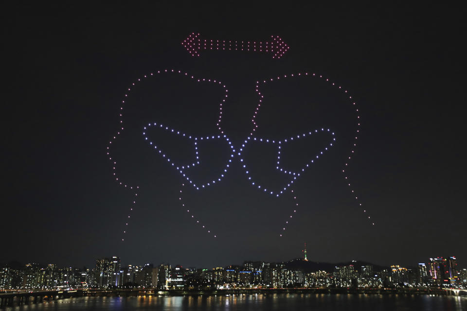 In this on Saturday, July 4, 2020, photo, some 400 drones fly over the Han River showing messages of appreciation for medical workers during the coronavirus pandemic in Seoul, South Korea. (Lim Hwa-young/Yonhap via AP)