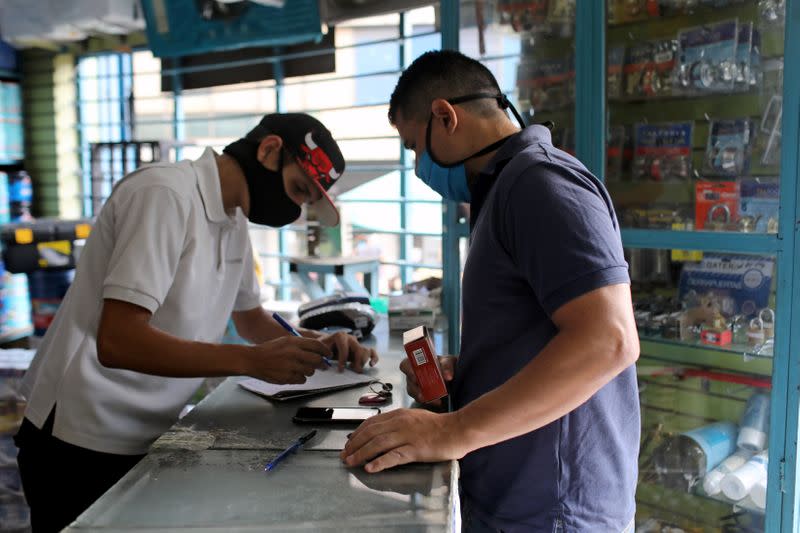 Physical education teacher Victor Carrillo buys supplies at a shop in Caracas