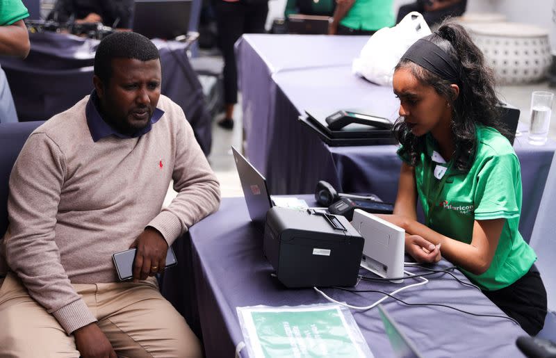 An employee serves a Safaricom Ethiopia client at their customer service desk during the service launch in Addis Ababa