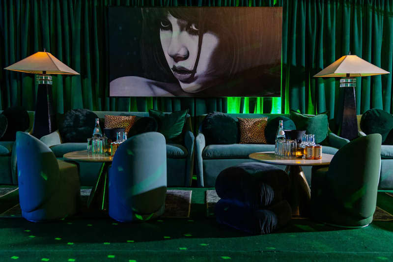 room with green velvet sofa and blue and green velvet chairs