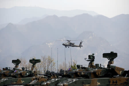 FILE PHOTO: A U.S. Army's AH-64 Apache helicopter flies over amoured vehicles, during a U.S.-South Korea joint live-fire military exercise, at a training field, near the demilitarized zone, separating the two Koreas in Pocheon, South Korea April 21, 2017. REUTERS/Kim Hong-Ji/File Photo