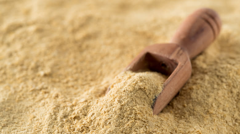 Pile of nutritional yeast and wooden scoop