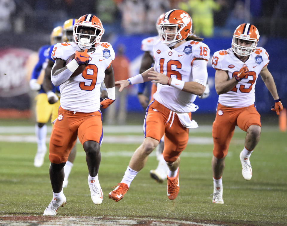 Clemson's Travis Etienne (9) runs for a touchdown against Pittsburgh as Trevor Lawrence (16) follows in the first half of the Atlantic Coast Conference championship NCAA college football game in Charlotte, N.C., Saturday, Dec. 1, 2018. (AP Photo/Mike McCarn)