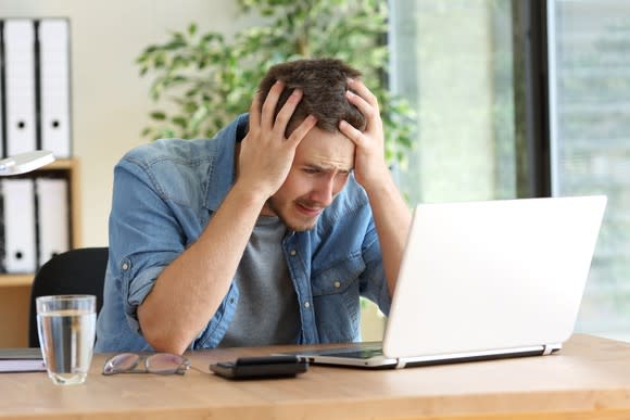 Frustrated man looking at computer