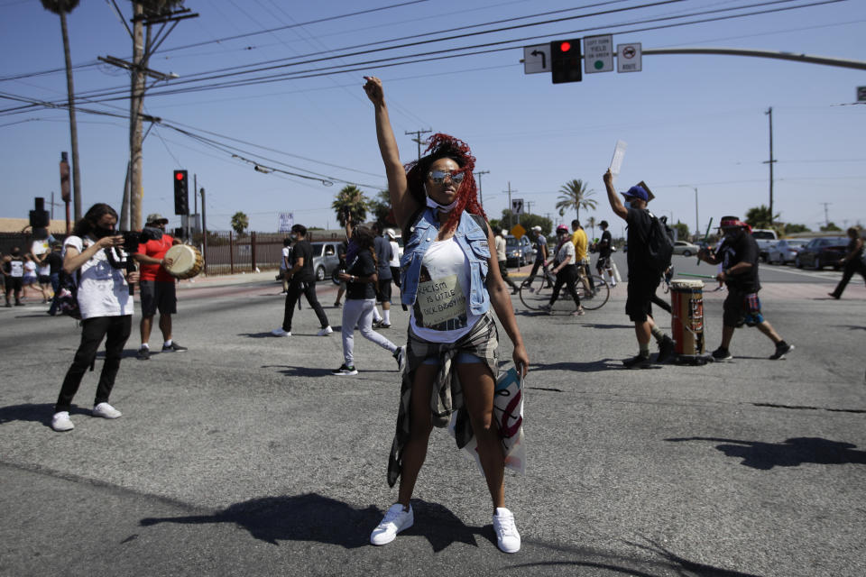 A protester raises her fist during a march in honor of Andres Guardado on Sunday, June 21, 2020, in Compton, Calif. Guardado was shot Thursday after Los Angeles County sheriff's deputies spotted him with a gun in front of a business near Gardena. (AP Photo/Marcio Jose Sanchez)