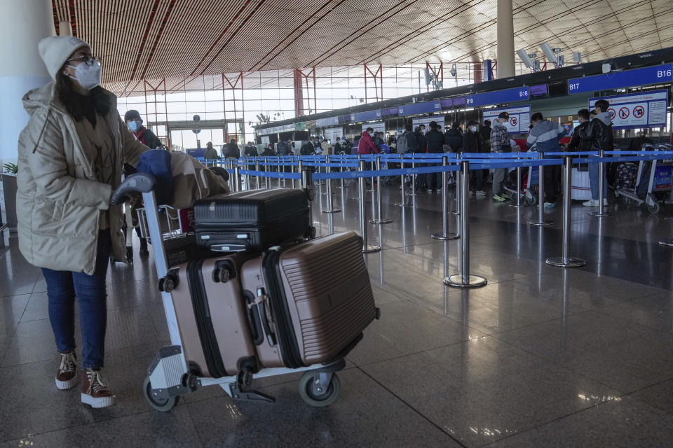 A masked traveller arrives at the international flight check in counter at the Beijing Capital International Airport in Beijing, Thursday, Dec. 29, 2022. Moves by the U.S., Japan and others to mandate COVID-19 tests for passengers arriving from China reflect global concern that new variants could emerge in its ongoing explosive outbreak — and the government may not inform the rest of the world quickly enough. (AP Photo/Andy Wong)