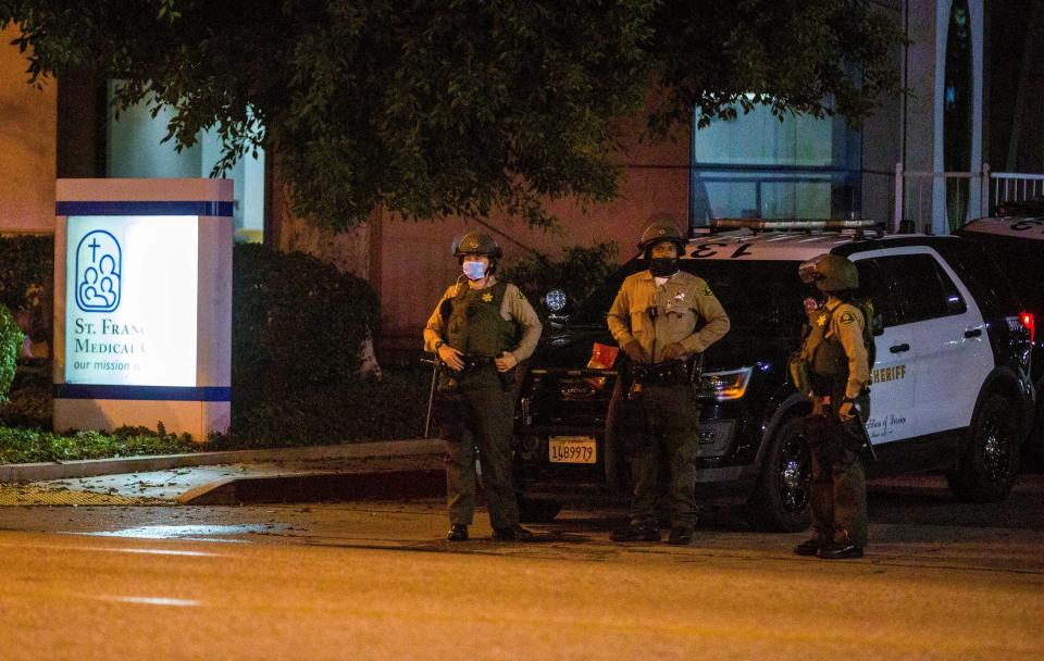 Los Angeles County Sheriff's deputies guard the entrance to St. Francis Medical Center early Monday, Sept. 13, 2020, after two deputies were shot late Saturday, Sept. 12 while sitting inside their patrol vehicle guarding a Metro station in Compton, Calif. (AP Photo/Jintak Han)