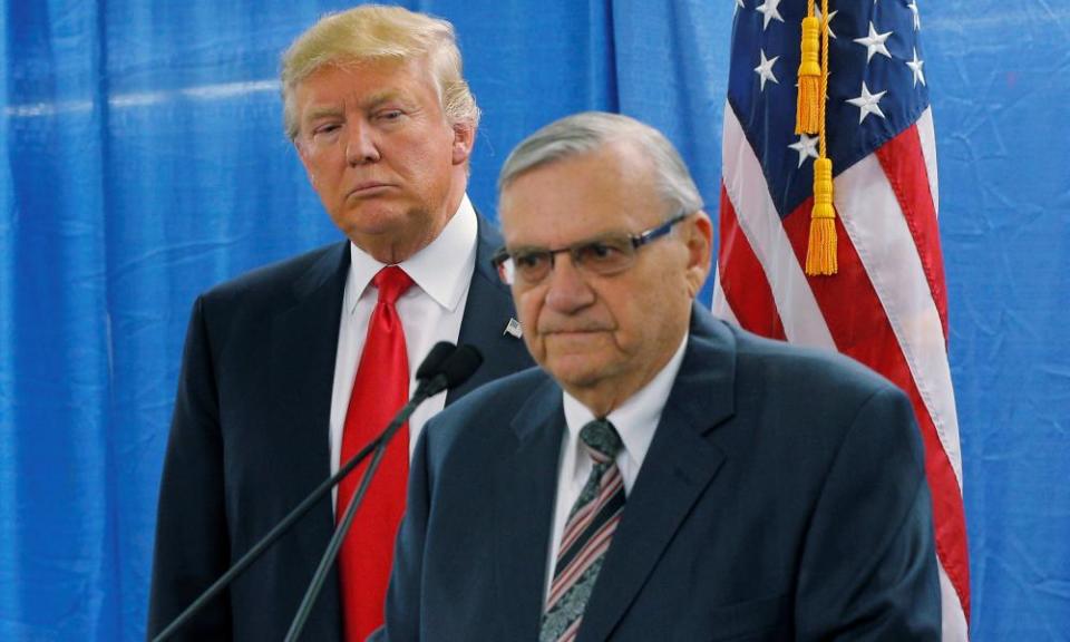 Trump, then a presidential candidate, listens as the then sheriff Joe Arpaio speaks to reporters before a campaign rally in Marshalltown, Iowa, in January 2016.