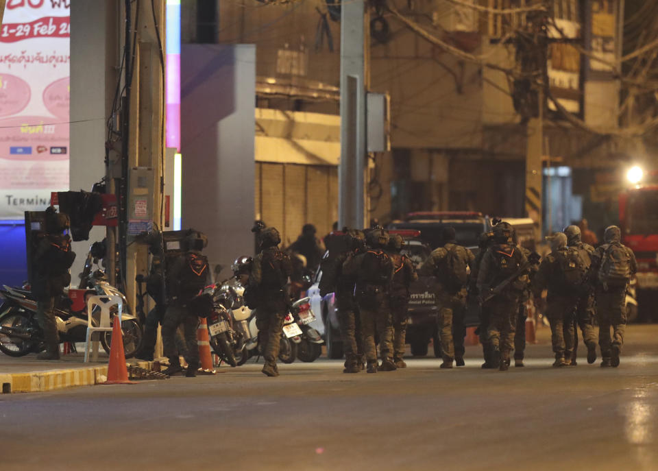 A group of armed commando soldiers are seen walking outside Terminal 21 Korat mall, in Nakhon Ratchasima, Thailand on Sunday, Feb. 9, 2020.A soldier who holed up in a popular shopping mall in northeastern Thailand shot multiple people on Saturday, killing at least 20 and injuring 31 others, officials said. (AP Photo/Sakchai Lalitkanjanakul)