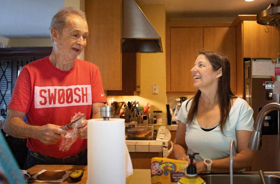 Isabel Toca, a breast cancer survivor, right, prepares for tea while her husband, Mario, makes a snack in their home on Wednesday, Oct. 4, 2023, in Miami, Fla. “Most people couldn’t work with their partners but it works because we’re both strong personalities,” said Toca. “I think I’m pretty easy,” Mario said.