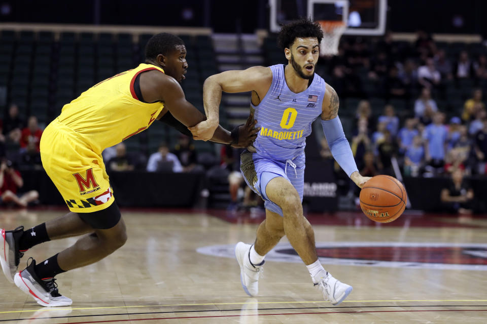 Marquette guard Markus Howard (0) is fouled by Maryland guard Darryl Morsell, left, during the first half of an NCAA college basketball game Sunday, Dec. 1, 2019, in Lake Buena Vista, Fla. (AP Photo/Scott Audette)