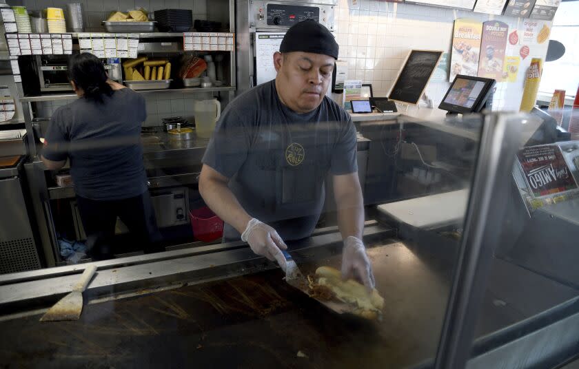 Ricardo Acosta prepares food at a Taco John's restaurant in Denver on Tuesday, May 16, 2023. Taco Bell is asking U.S. regulators to force Wyoming-based Taco John's to abandon its longstanding claim to the "Taco Tuesday" trademark. (AP Photo/Thomas Peipert)