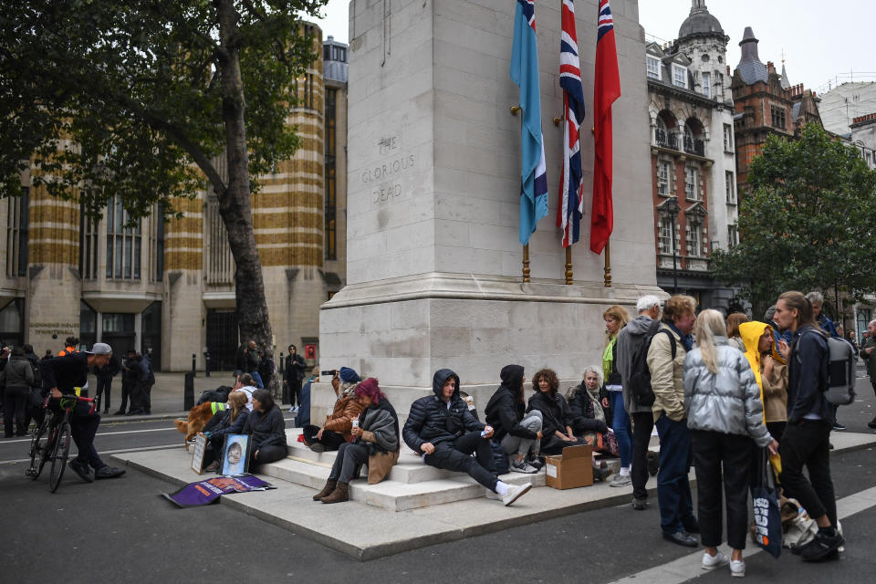 Anti-lockdown protesters sit on the Cenotaph.