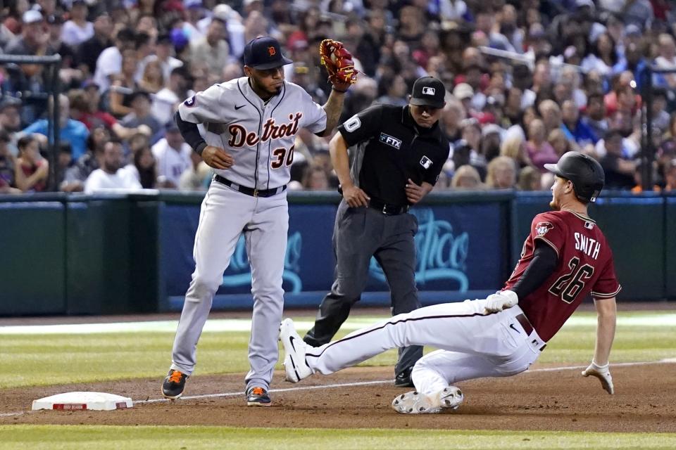 Detroit Tigers third baseman Harold Castro (30) forces out Arizona Diamondbacks' Pavin Smith (26) at third base as umpire Roberto Ortiz looks on during the sixth inning of a baseball game Sunday, June 26, 2022, in Phoenix. (AP Photo/Ross D. Franklin)