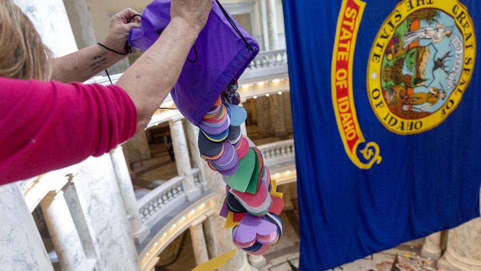 AlexaLynne Fill, of Nampa, dumps one of several bags of handmade paper hearts, totaling over 48,000, from the fourth floor of the Idaho Capitol rotunda during a demonstration by members of the LGBTQ+ community, Tuesday, April 2, 2024. Sarah A. Miller/smiller@idahostatesman.com