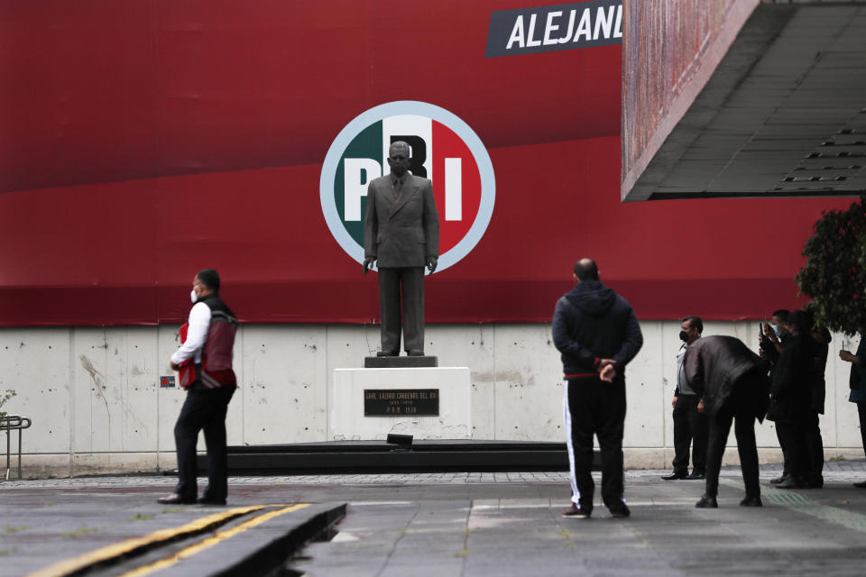 Security guards stand inside the closed headquarters of the Institutional Revolutionary Party of Mexico, PRI, in Mexico City, on Wednesday, June 30, 2021. The doors were closed after party dissidents set up a ring of protesters Tuesday around the headquarters and fighting apparently broke out when a squad of loyalists tried to retake the building. (AP Photo/Marco Ugarte)