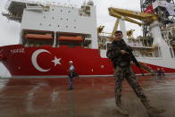 FILE - In this Thursday, June 20, 2019 file photo, a Turkish police officer patrols the dock, backdropped by the drilling ship 'Yavuz' to be dispatched to the Mediterranean, at the port of Dilovasi, outside Istanbul. The leaders of Greece, Israel and Cyprus are set to sign a deal Thursday Jan. 2, 2020, for a 1,900-kilometer (1,300-mile) undersea pipeline that will carry gas from new offshore deposits in the southeastern Mediterranean to continental Europe. (AP Photo/Lefteris Pitarakis, File)