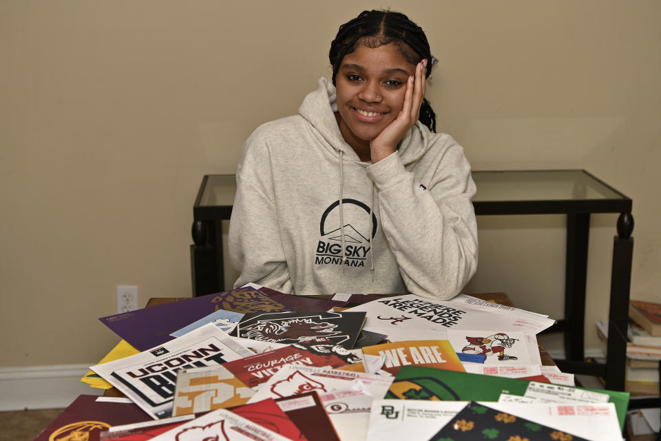 Sacred Heart Academy guard ZaKiyah Johnson sits in front of some of the many recruitment letters she has received at her home in Shelbyville, Ky., Sunday, Feb. 11, 2024. The junior wing ranked as a top-five overall prospect for next season has pared her list down to a dozen schools, an elite group that includes defending national champion LSU, current No. 1 and two-time champ South Carolina and of course, nearby Louisville. (AP Photo/Timothy D. Easley)