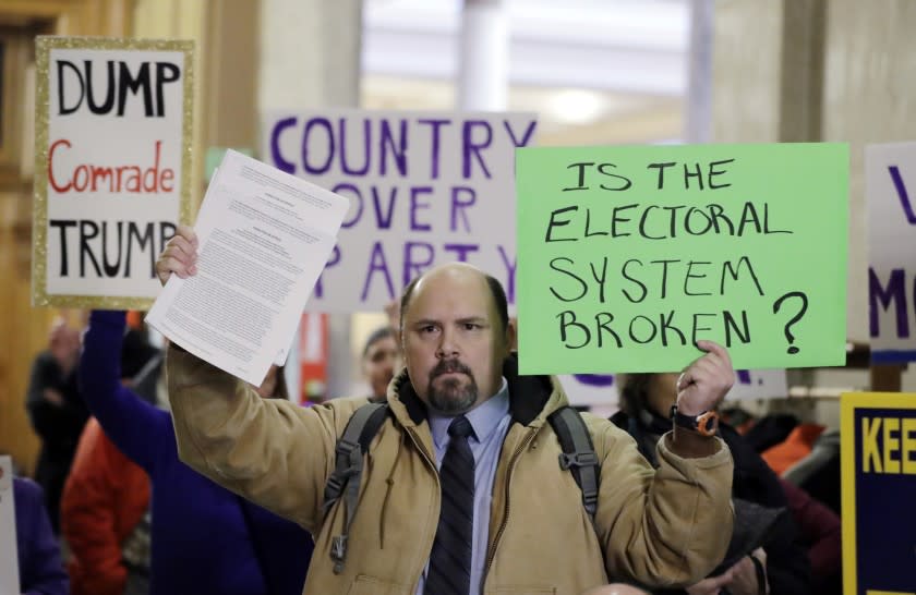 Brock Ervin demonstrates outside the Indiana House chamber before the state's eleven electors cast ballots for president and vice president.