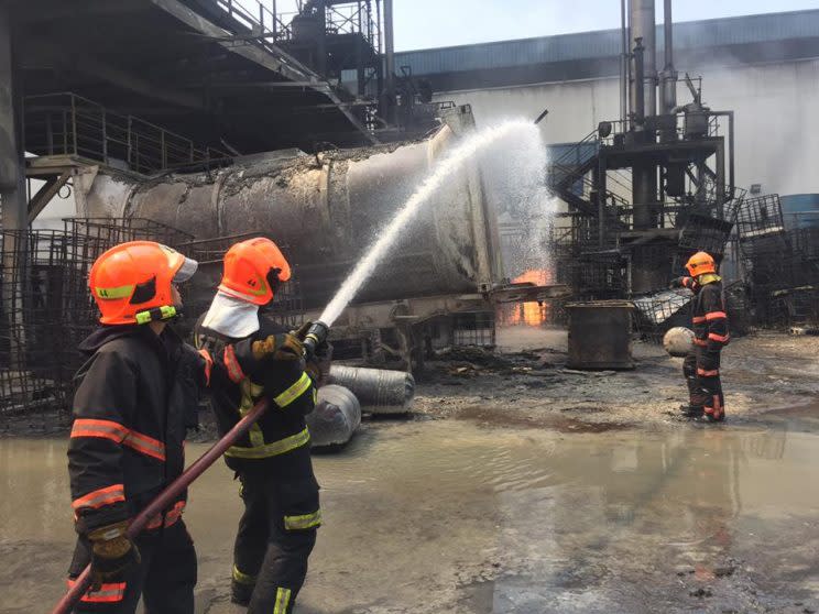 Firefighters spraying a pocket of fire with foam at 23 Tuas View Circuit. (Photo: SCDF)