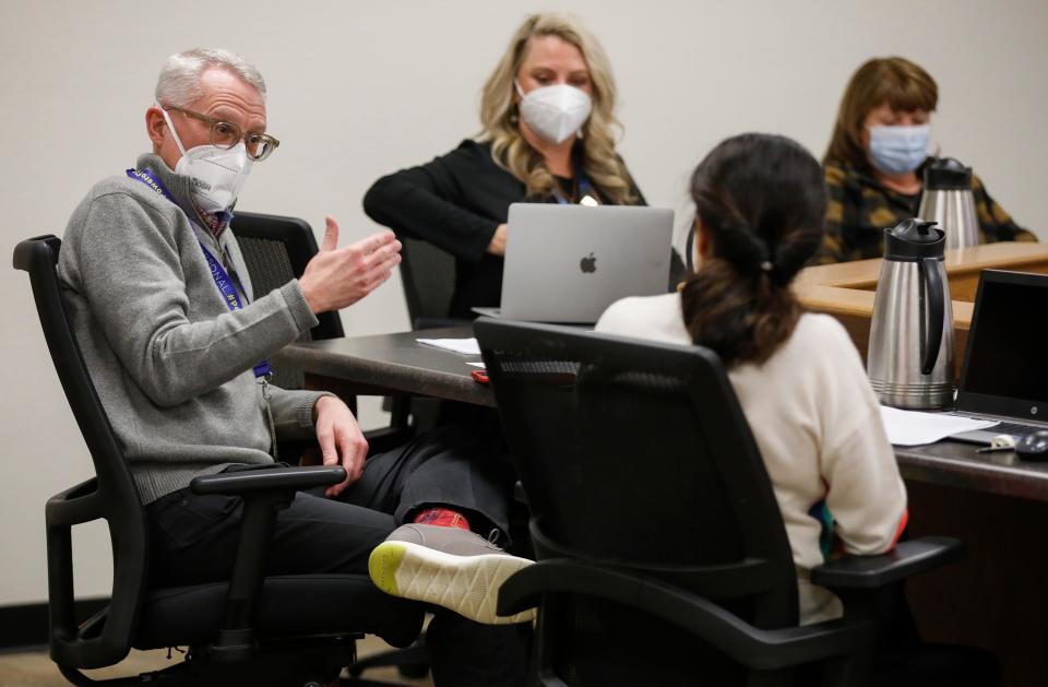 Springfield school members Charles Taylor, left, and Maryam Mohammadkhani, right, have a discussion during a meeting to decide on whether to reinstate a temporary mask mandate.