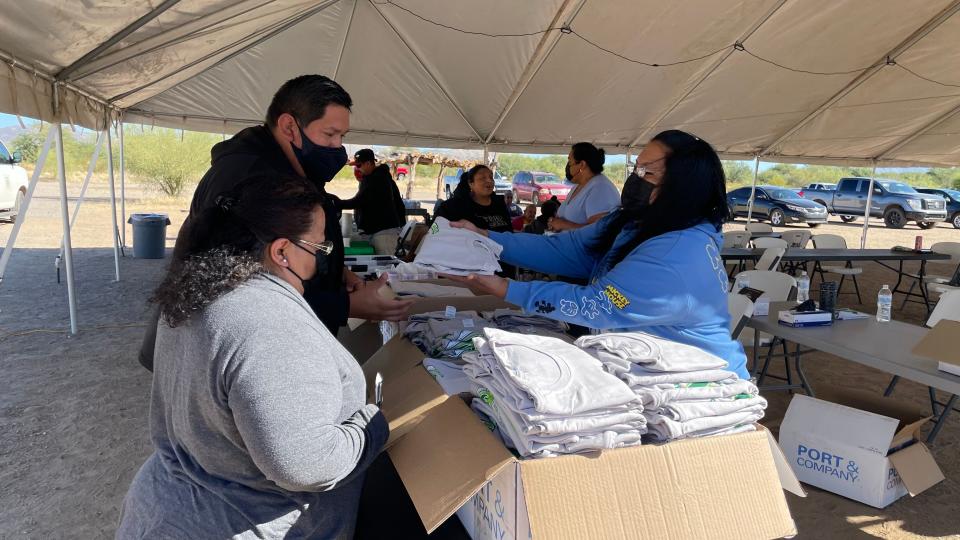 Carline Lopez, an employee with Komckud E-wa’osidk Ceksan/Sells District Administration Office, gives T-shirts to voters who cast their ballots at the district office in Sells on Nov. 8.