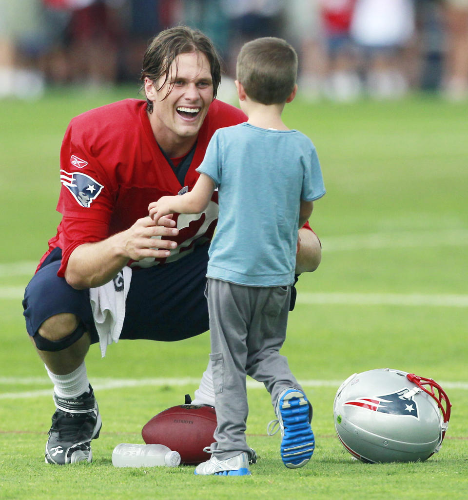 New England Patriots' Tom Brady greets his son Jack on the field after NFL football training camp Tuesday, Aug. 9, 2011, in Foxborough, Mass. (AP Photo/Michael Dwyer)