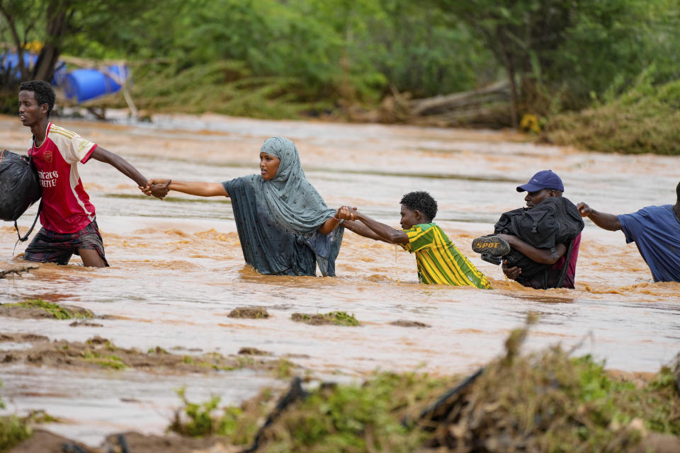 FILE - Residents cross a road damaged by El Niño rains in Tula, Tana River county in Kenya on Saturday Nov. 25, 2023. Severe flooding in the country has killed dozens and displaced thousands, according to estimates from the UN Office for the Coordination of Humanitarian Affairs. (AP Photo/Brian Inganga, File)