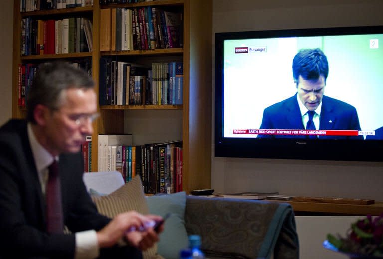 Norway's Prime Minister Jens Stoltenberg checks e-mails on his phone while a press conference by Statoil CEO Helge Lund is displayed on TV at his residence in Oslo during a crisis meeting regarding the hostage situation in IN Amenas Algeria on January 17, 2013