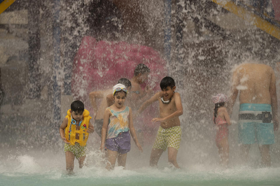 Niños y adultos escapan del fuerte calor en el Centro Acuático Bagdad, en Bagdad, Irak, el jueves 6 de julio de 2023. (AP Foto/Hadi Mizban)