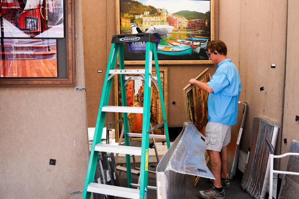 John Galbo, 80, of Boca Raton, Florida prepares his booth at the Ann Arbor Art Fair in Ann Arbor on Wednesday, July 19, 2023. The 3-day fair features almost 1,000 artists and draws in close to half a million attendees each year. Galbo is a photographer and painter but prides himself on his painterly landscape photographs.