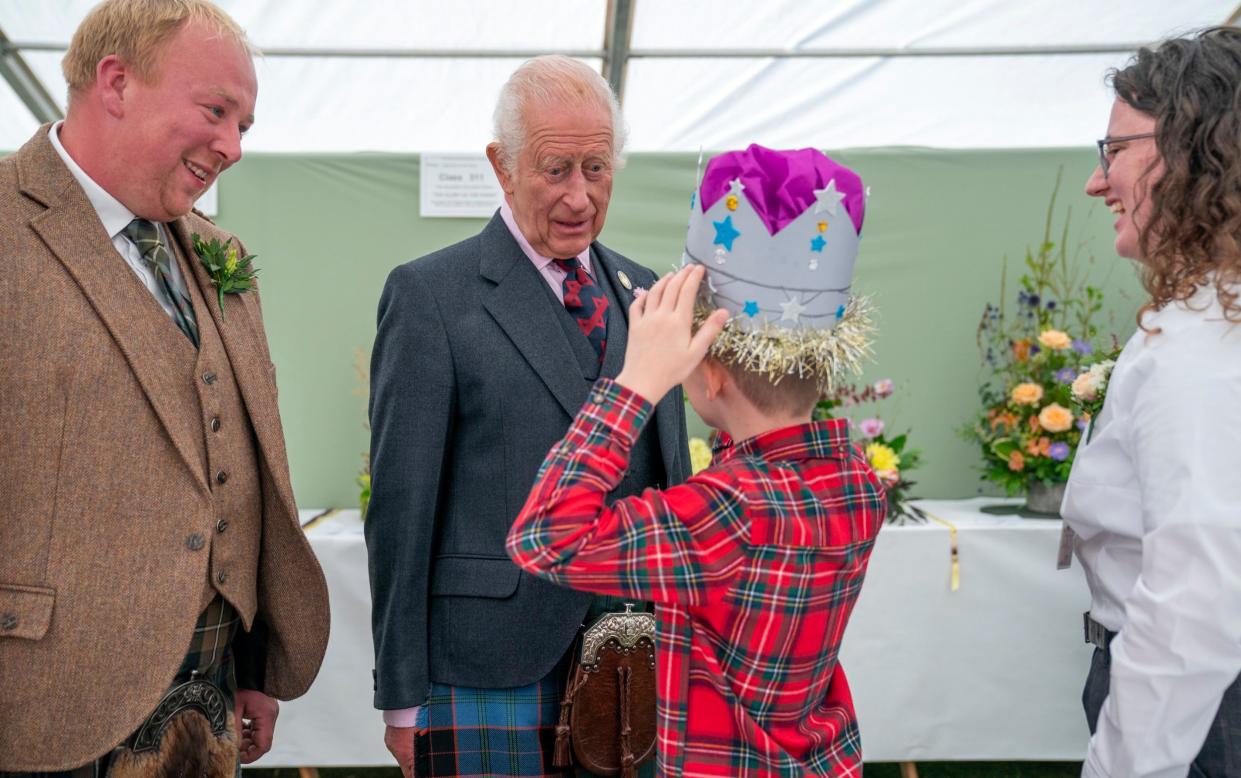 Oliver Keith, 8, from Portlethen, shows the King a paper crown he made at the flower show