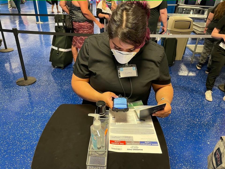 A cruise ship crew member checks my passport and my vaccination card before boarding the ship.