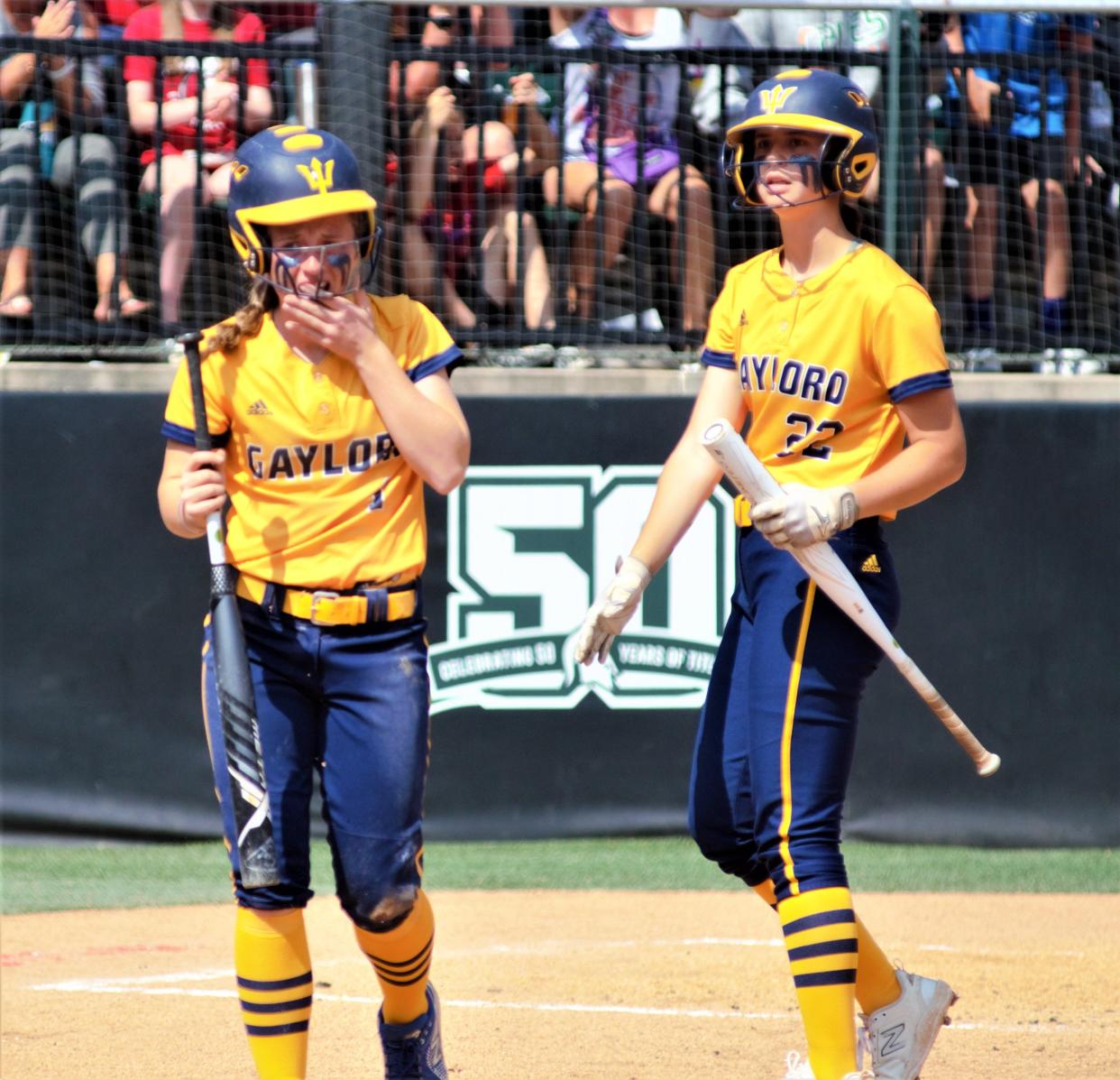 Nora Bethuy (left) holds her hand over her mouth after chipping her tooth while sliding into home plate during the 2023 Division 2 softball state finals on Saturday, June 17 at Secchia Stadium on the campus of Michigan State University, East Lansing, Mich.