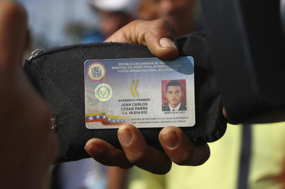 Defected Venezuelan National Guard sergeant Jean Carlos Cesar Parra shows his ID to the press after crossing the border to Pacaraima, Brazil, Sunday, Feb. 24, 2019 during a confrontation over aid shipments for Venezuela as its government closes its borders with Brazil and Colombia. There's been little suggestion any battalion or division commanders are willing to defect despite almost daily calls by Venezuelan opposition leader Juan Guaido and the U.S. (AP Photo/Edmar Barros)