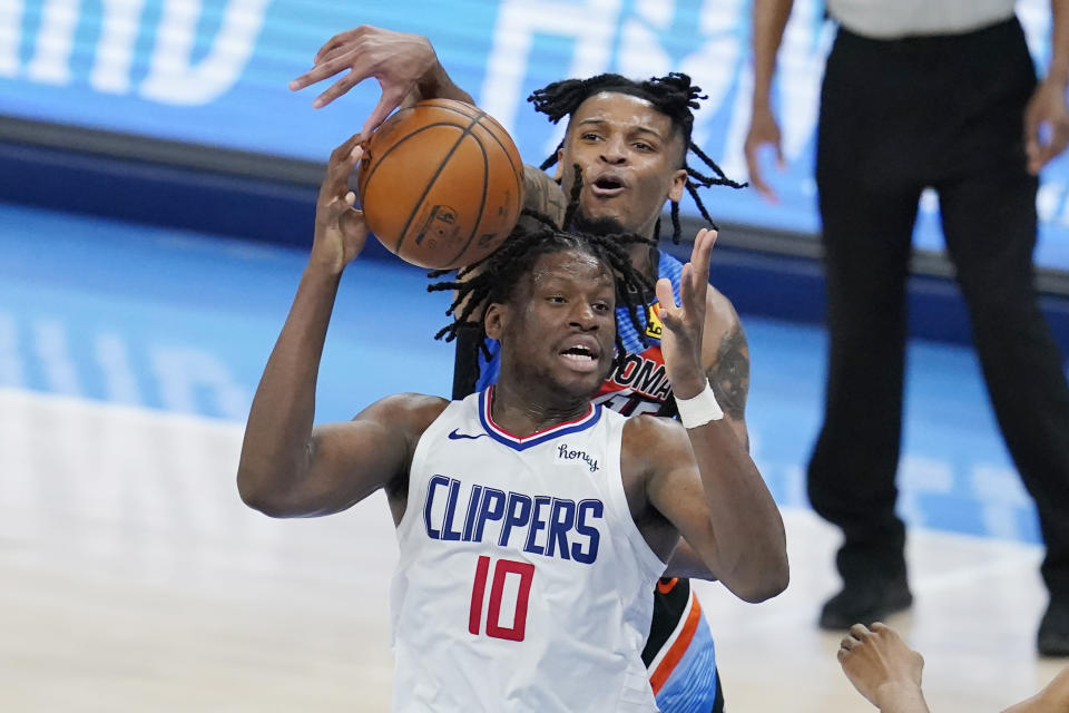 Oklahoma City Thunder forward Josh Hall, rear, tries to knock the ball away from Los Angeles Clippers center Daniel Oturu (10) in the second half of an NBA basketball game Sunday, May 16, 2021, in Oklahoma City. (AP Photo/Sue Ogrocki)